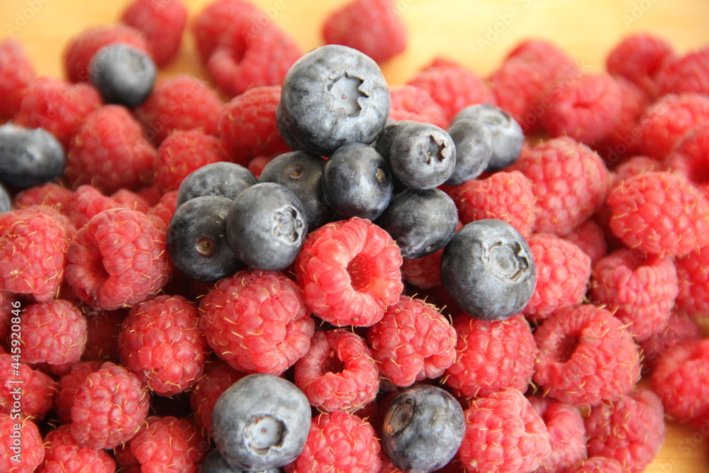 blueberries and raspberries on a wooden background blueberries and raspberries on a wooden background