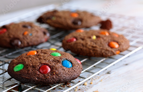 Chocolate soft cookies decorate topping with multi-colored candy.