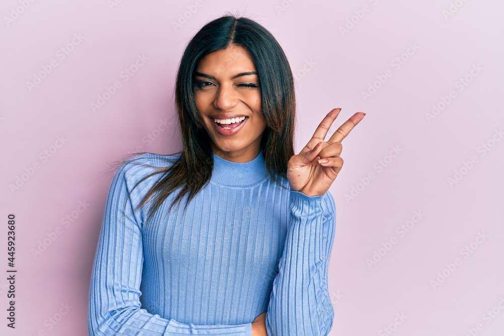 Young latin transsexual transgender woman wearing casual clothes smiling with happy face winking at the camera doing victory sign. number two. Young latin transsexual transgender woman wearing casual clothes smiling with happy face winking at the camera doing victory sign. number two.