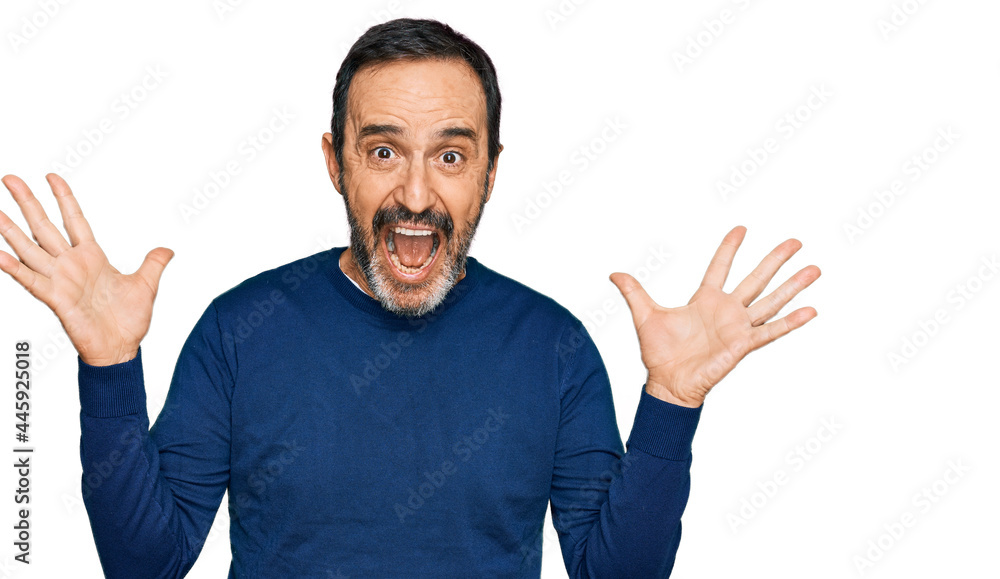 Middle age hispanic man wearing casual clothes celebrating crazy and amazed for success with arms raised and open eyes screaming excited. winner concept Middle age hispanic man wearing casual clothes celebrating crazy and amazed for success with arms raised and open eyes screaming excited. winner concept