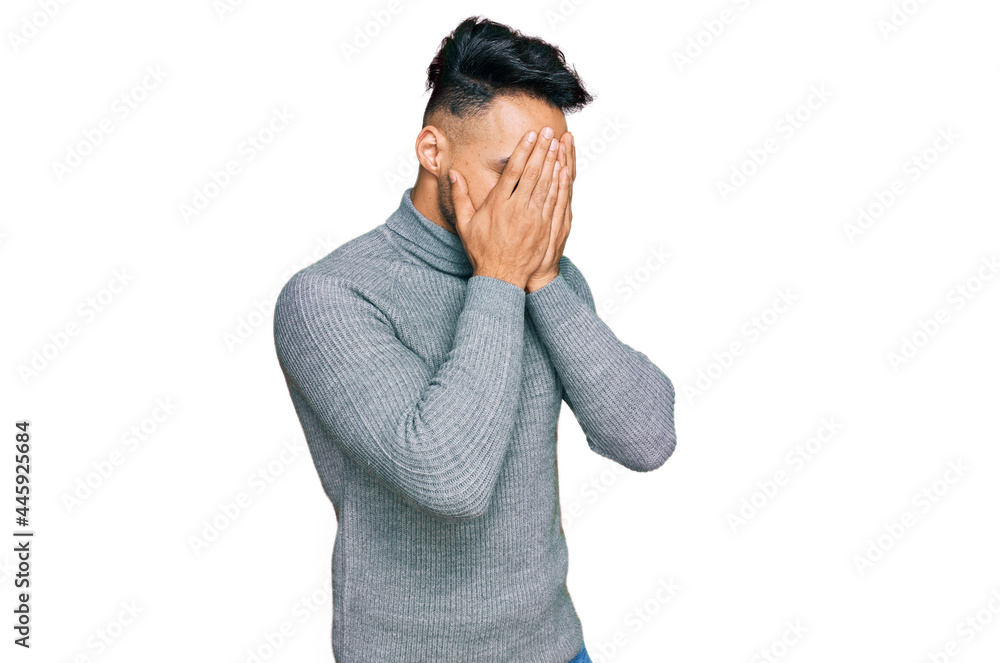 Young arab man wearing casual clothes with sad expression covering face with hands while crying. depression concept. Young arab man wearing casual clothes with sad expression covering face with hands while crying. depression concept.