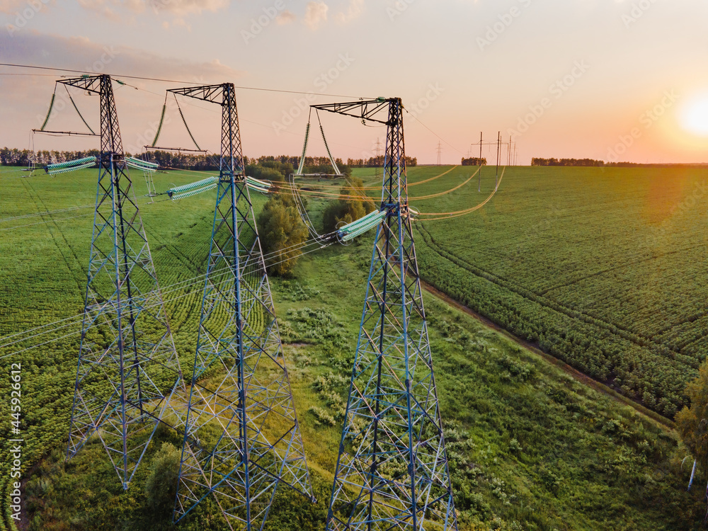 Overhead power line transmission tower at summer. Electricity pylon and High voltage grid tower with wire cable