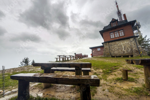 Wooden table and bench against viewpoint at a peak of Polish mountain called Lubon Wielki located in a region of Beskid Wyspowy famous for hike amongst tourists. A radio and tv broadcasting center