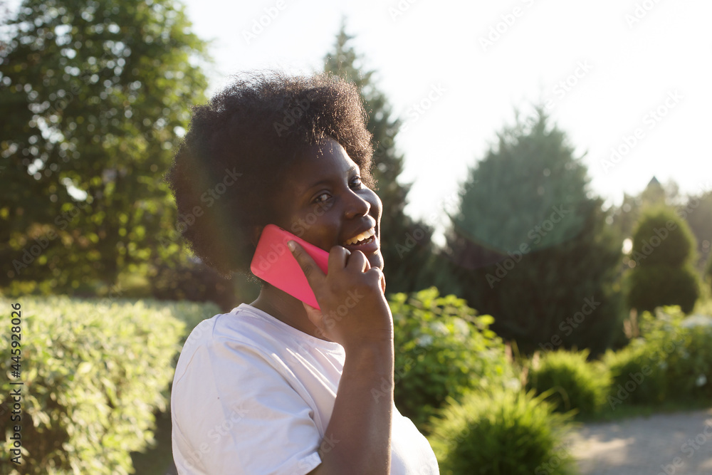 happy African American woman with a phone on the street in the summer happy African American woman with a phone on the street in the summer