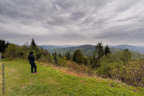Wielki Lubon, Poland : An unidentified man in black clothes standing by the cliff admiring view of Lubon Wielki mountain located in Poland during overcast cloudy weather.