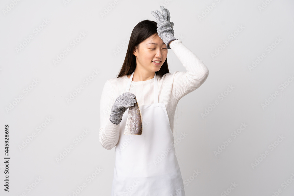 Chinese fishmonger wearing an apron and holding a raw fish over isolated white background has realized something and intending the solution Chinese fishmonger wearing an apron and holding a raw fish over isolated white background has realized something and intending the solution
