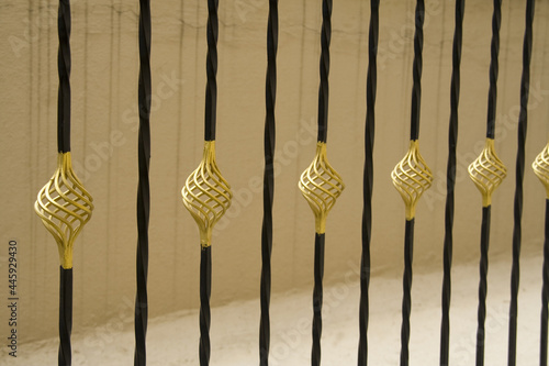 Closeup shot of gold and black painted decorative rod railing design photo