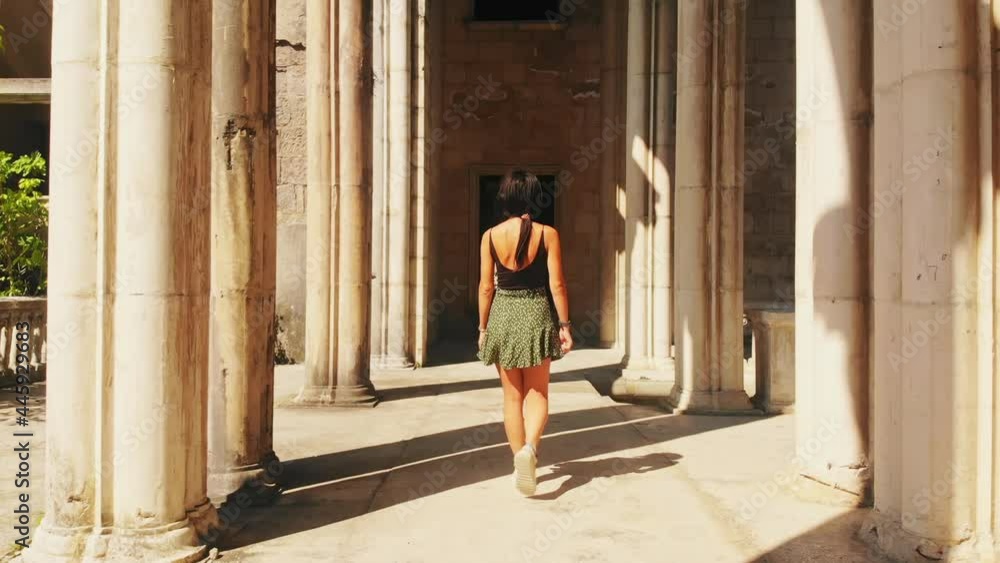 Back view caucasian beautiful woman in slow motion walk and admire historical landmark in sunny summer day. Female influencer on travel holiday Back view caucasian beautiful woman in slow motion walk and admire historical landmark in sunny summer day. Female influencer on travel holiday