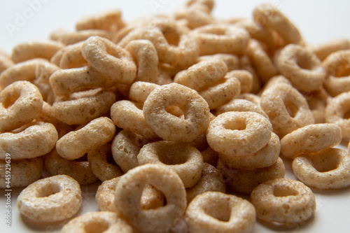 Closeup of a heap of Cereal cheerios on white background, rings breakfast cereal © Leonardo Severini