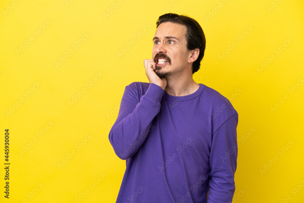 Young caucasian man isolated on yellow background is a little bit nervous Young caucasian man isolated on yellow background is a little bit nervous