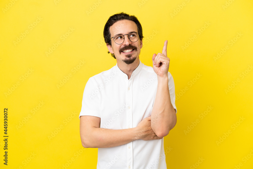 Young caucasian man isolated on yellow background pointing up a great idea Young caucasian man isolated on yellow background pointing up a great idea