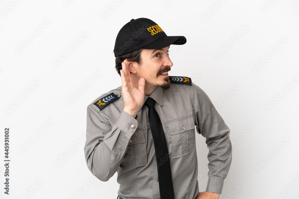 Young caucasian security man isolated on white background listening to something by putting hand on the ear Young caucasian security man isolated on white background listening to something by putting hand on the ear