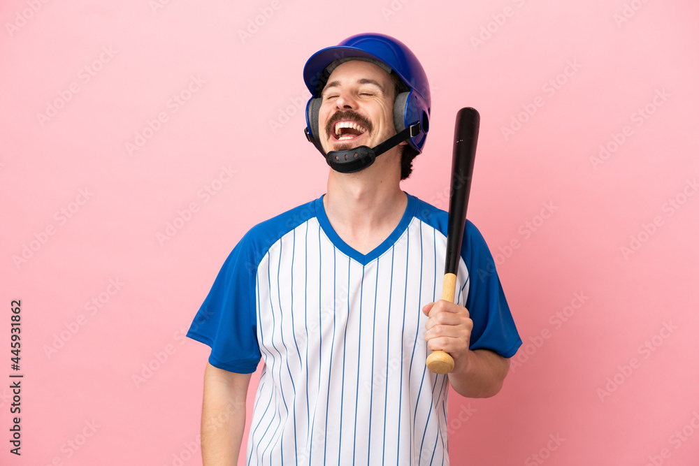 Young caucasian man playing baseball isolated on pink background laughing Young caucasian man playing baseball isolated on pink background laughing