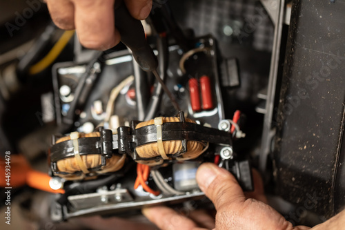 close-up. The hands of a working electrician in the process of repairing an electric generator in a masterx. Workplace mechanic
