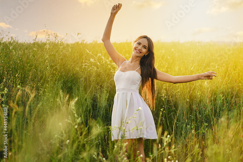 Beautiful young woman dancing in the field