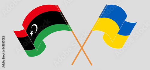 Crossed and waving flags of Libya and Ukraine