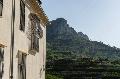 Windows with wrought iron bars, in a rural house with mountains in the background. photo