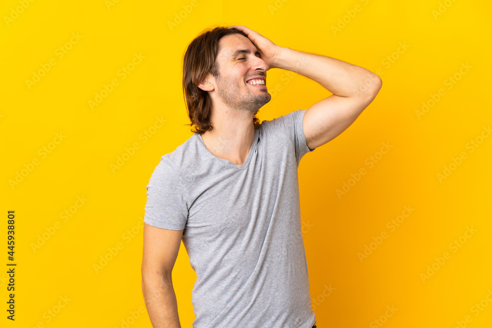 Young handsome man isolated on yellow background smiling a lot