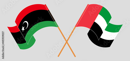 Crossed and waving flags of Libya and the United Arab Emirates