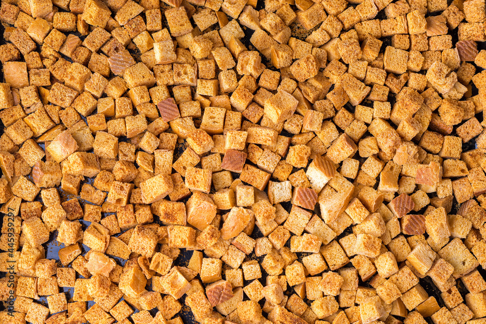 Square-shaped bread crumbs. Oven-fried golden brown bread crumbs. Background. Square-shaped bread crumbs. Oven-fried golden brown bread crumbs. Background.