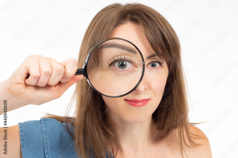 Woman with magnifying glass. Girl with magnifying glass near her eye. Woman portrait on white background.Girl is looking for something. Businesswoman looking at the screen through a magnifying glass Woman with magnifying glass. Girl with magnifying glass near her eye. Woman portrait on white background.Girl is looking for something. Businesswoman looking at the screen through a magnifying glass