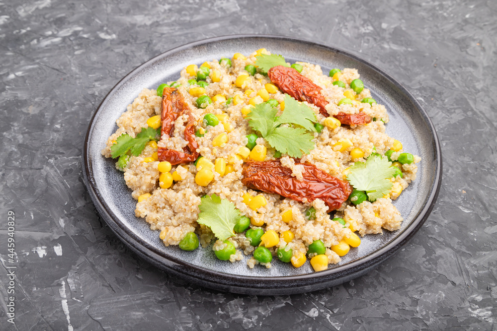Quinoa porridge with green pea, corn and dried tomatoes on ceramic plate on a gray concrete background. Side view. Quinoa porridge with green pea, corn and dried tomatoes on ceramic plate on a gray concrete background. Side view.