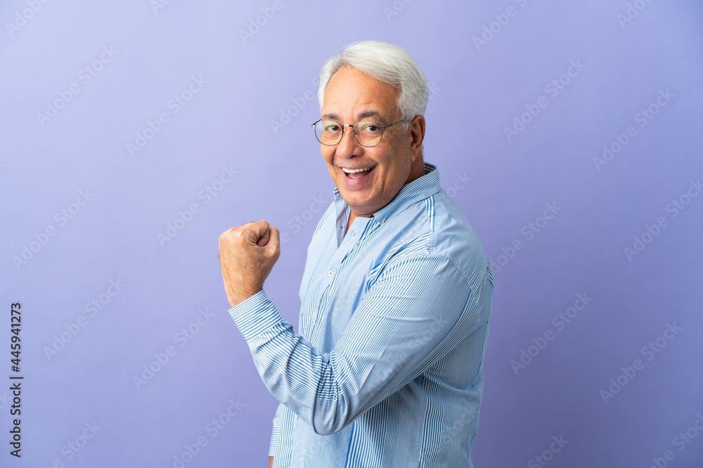 Middle age Brazilian man isolated on purple background celebrating a victory Middle age Brazilian man isolated on purple background celebrating a victory