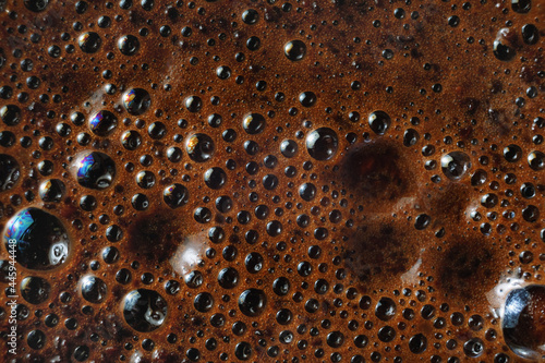 Closeup of coffee foam background. Macro texture of brown coffee foam.