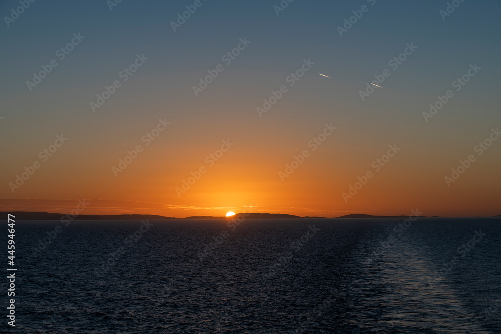 Sunset at sea. Seascape, blue sea.  Calm weather. View from cargo vessel.