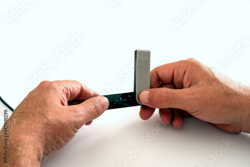 Investor  man holding digital Cryptocurrency USB hardware wallet  ledger isolated on white background. photo