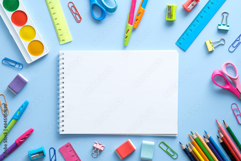 Back to school concept. Flat lay style composition with stationery and notepad on blue background. Top view, overhead Back to school concept. Flat lay style composition with stationery and notepad on blue background. Top view, overhead