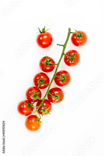 Branch of cherry tomatoes with one separated from the group on bright white background