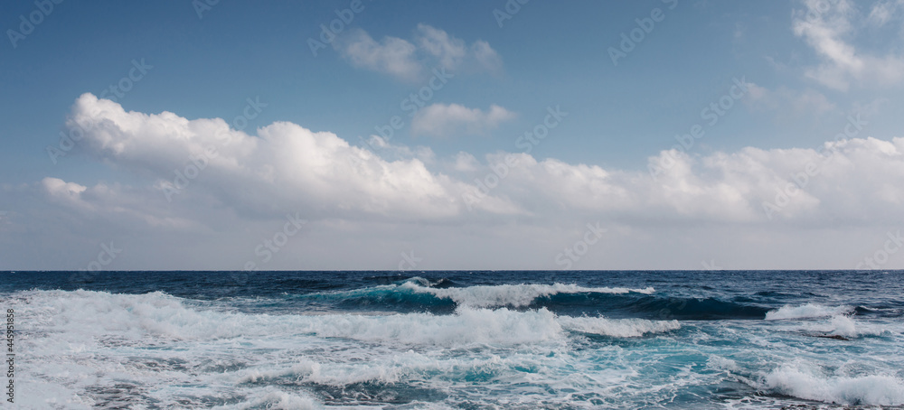 Sea waves crash on the rough rocky shore