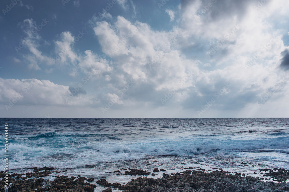 Sea waves crash on the rough rocky shore