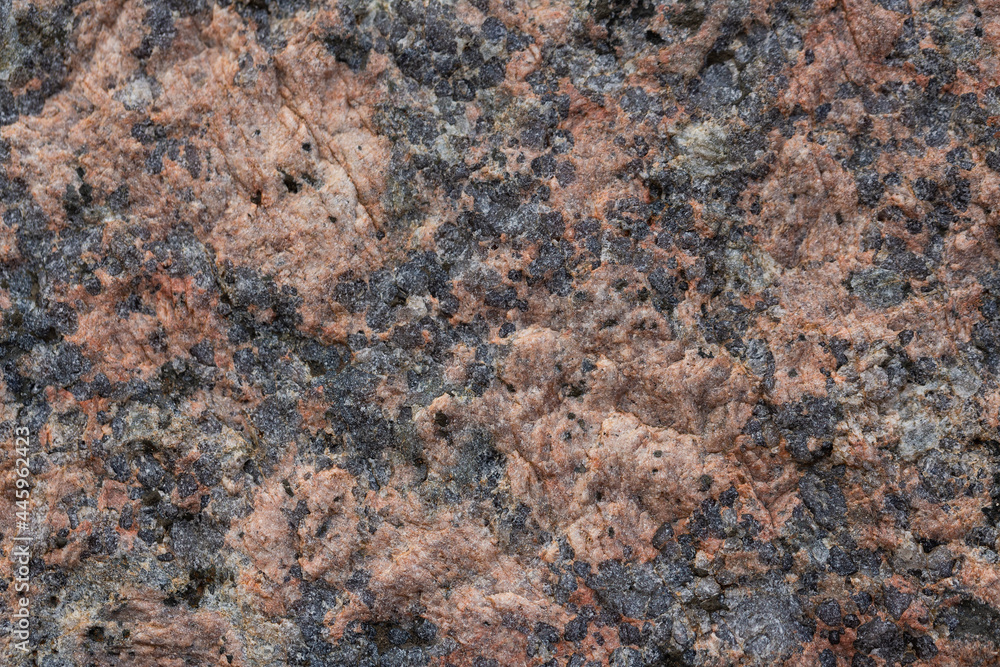Granite texture. Natural pink granite with a grainy pattern. Stone background. Solid rough surface of rock. Durable construction and decoration material. Close-up. Granite texture. Natural pink granite with a grainy pattern. Stone background. Solid rough surface of rock. Durable construction and decoration material. Close-up.