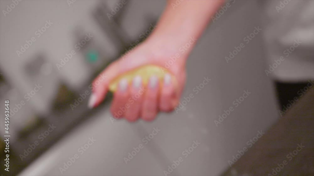 Woman hand squeeze fresh citrus lemon in kitchen close up, slow motion Woman hand squeeze fresh citrus lemon in kitchen close up, slow motion
