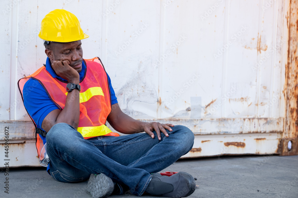 African American foreman or container worker sit and look like sleep to relax after finish his work in workplace. African American foreman or container worker sit and look like sleep to relax after finish his work in workplace.