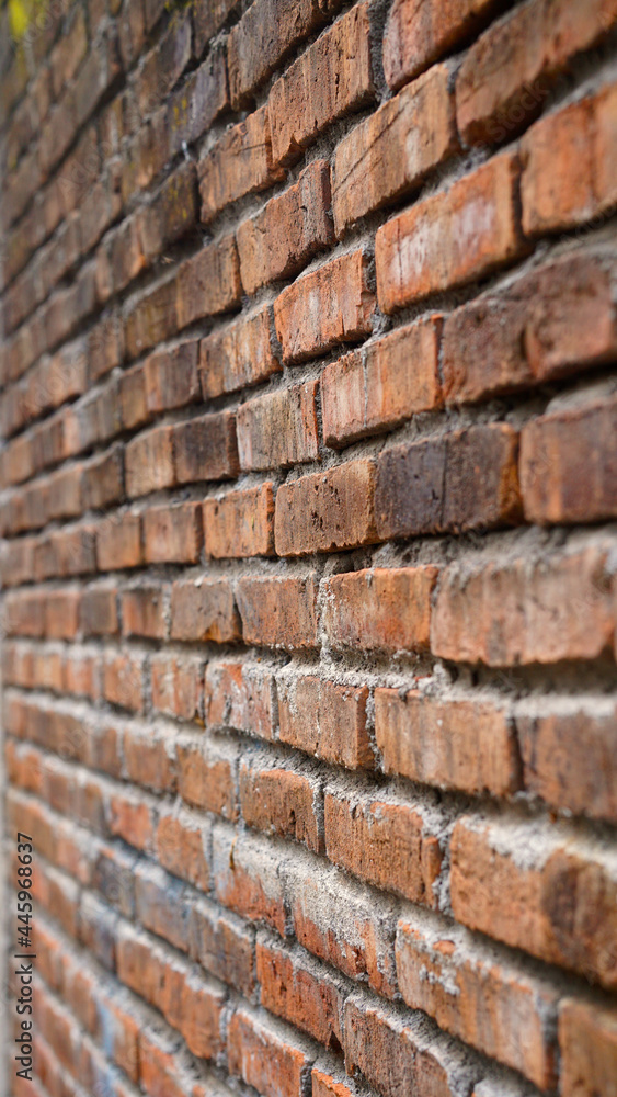 Red brick wall from the side, focus selected, blur on the far side Red brick wall from the side, focus selected, blur on the far side