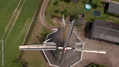 Top down aerial view of Dutch windmill descending revealing texture and detail of the wicks from up close in countryside of The Netherlands photo