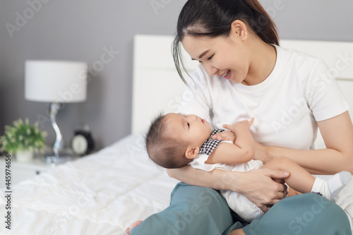 mother holding newborn baby in a tender embrace on bed
