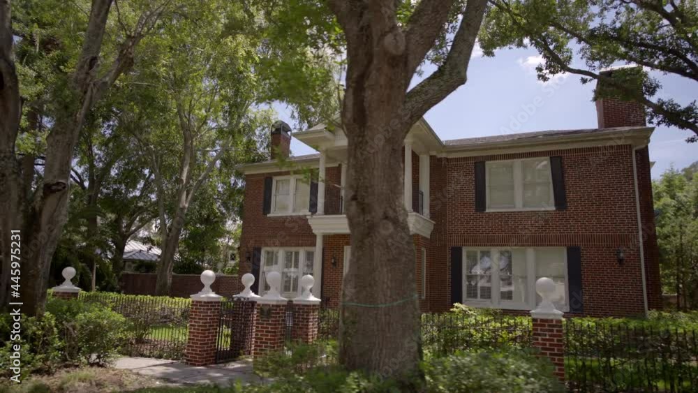 Old 2 story brick house with trees and gate Old 2 story brick house with trees and gate