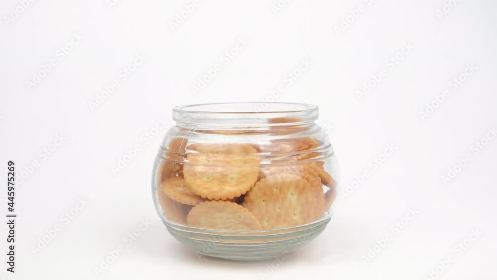 Hand picking Biscuits cookies in a glass jar on white background. Hand picking Biscuits cookies in a glass jar on white background.
