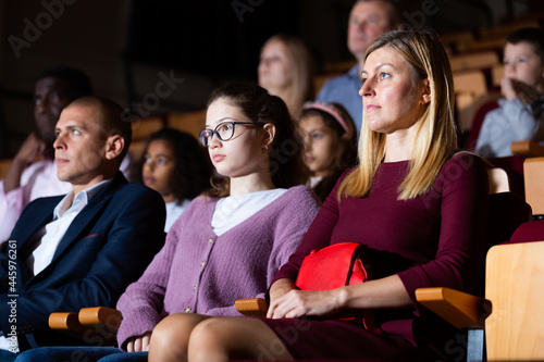 parents with children sitting at premiere in theatrical auditorium photo