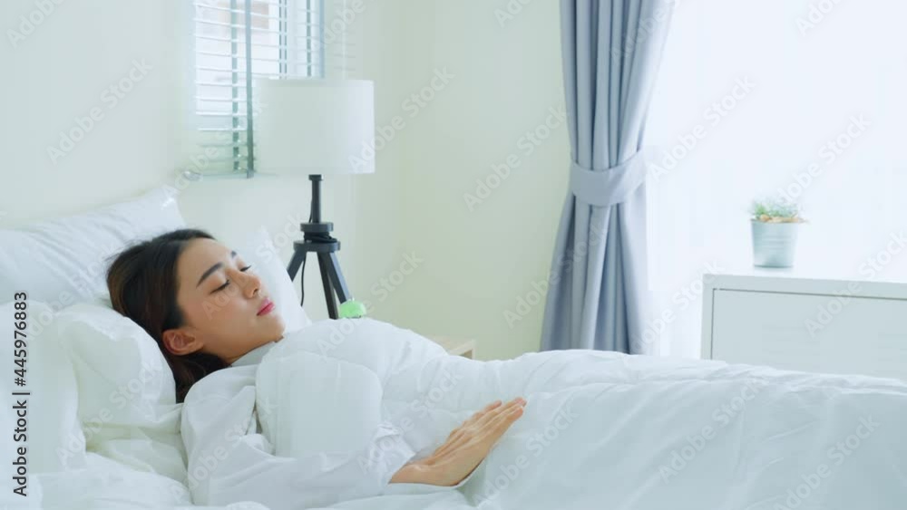 Asian beautiful sick girl in pajamas getting up from sleep in bedroom. Asian beautiful sick girl in pajamas getting up from sleep in bedroom.