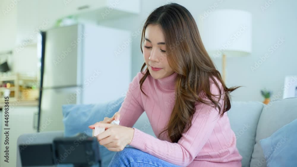 Asian female vlogger talk with camera to review the cosmetic at home. Asian female vlogger talk with camera to review the cosmetic at home.