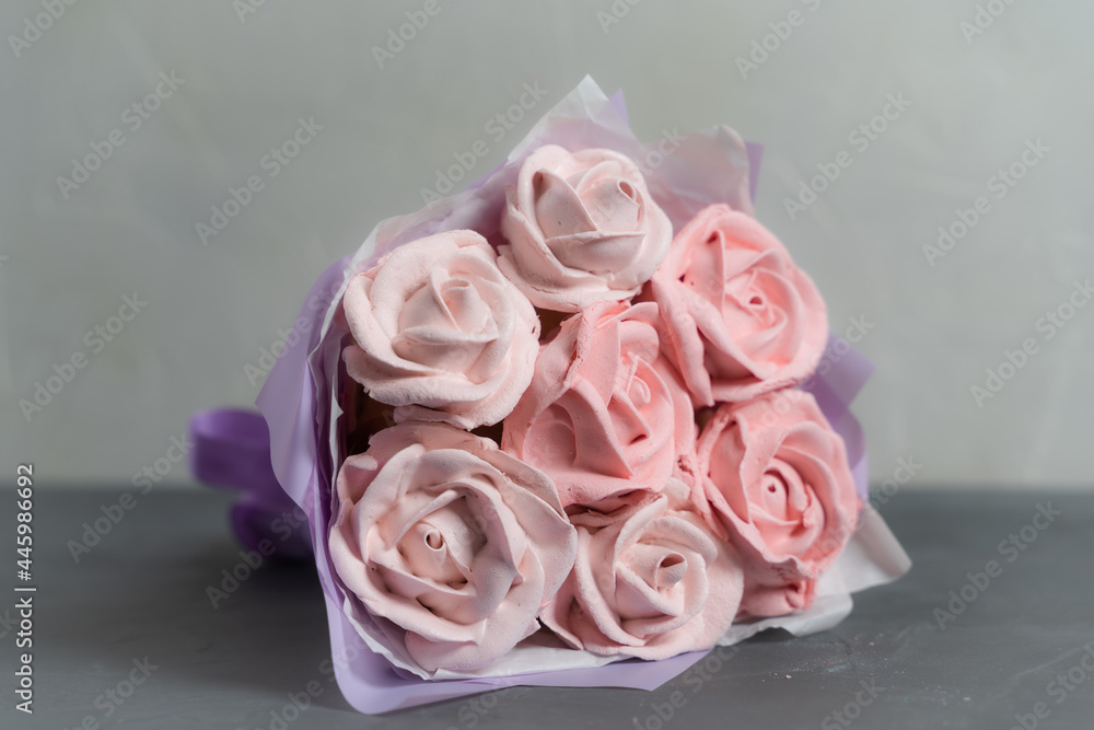 Fototapeta premium Bouquet of marshmallows. Marshmallow roses and tulips are collected in a bouquet. Packed in paper and gift box. A sweet gift for loved ones. A gift to your beloved.