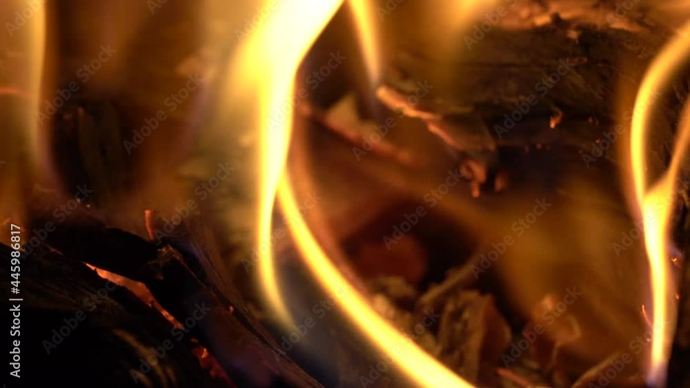 Macro shot of flames around the burned embers of a log in a fireplace Macro shot of flames around the burned embers of a log in a fireplace