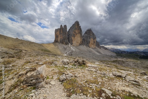 Magnificent scenery of the north face of Tre Cime di Lavaredo ( Drei Zinnen ) under dramatic moody sky on a cloudy summer day in Dolomites, South Tyrol, Italy, Europe