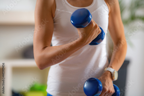 Woman Exercising with Dumbbells. Exercise for Biceps.