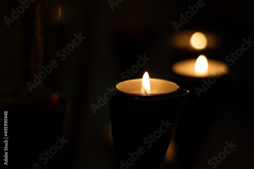 candles lit in the dark of a church © Em Neems Photography